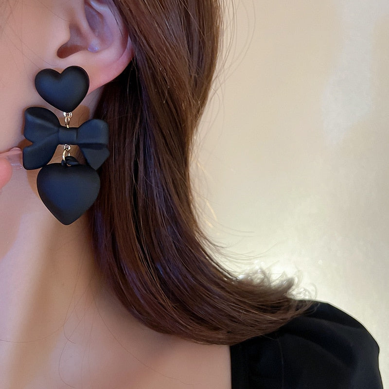 Women’s black heart earrings with a bow